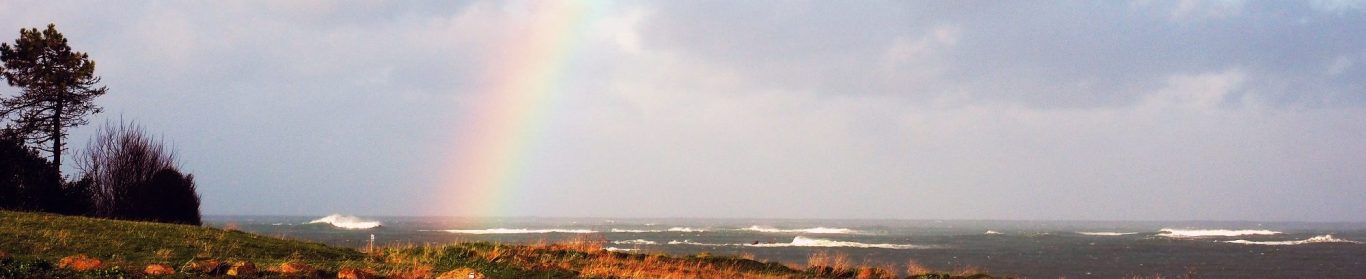 Regenbogen berührt das Meer